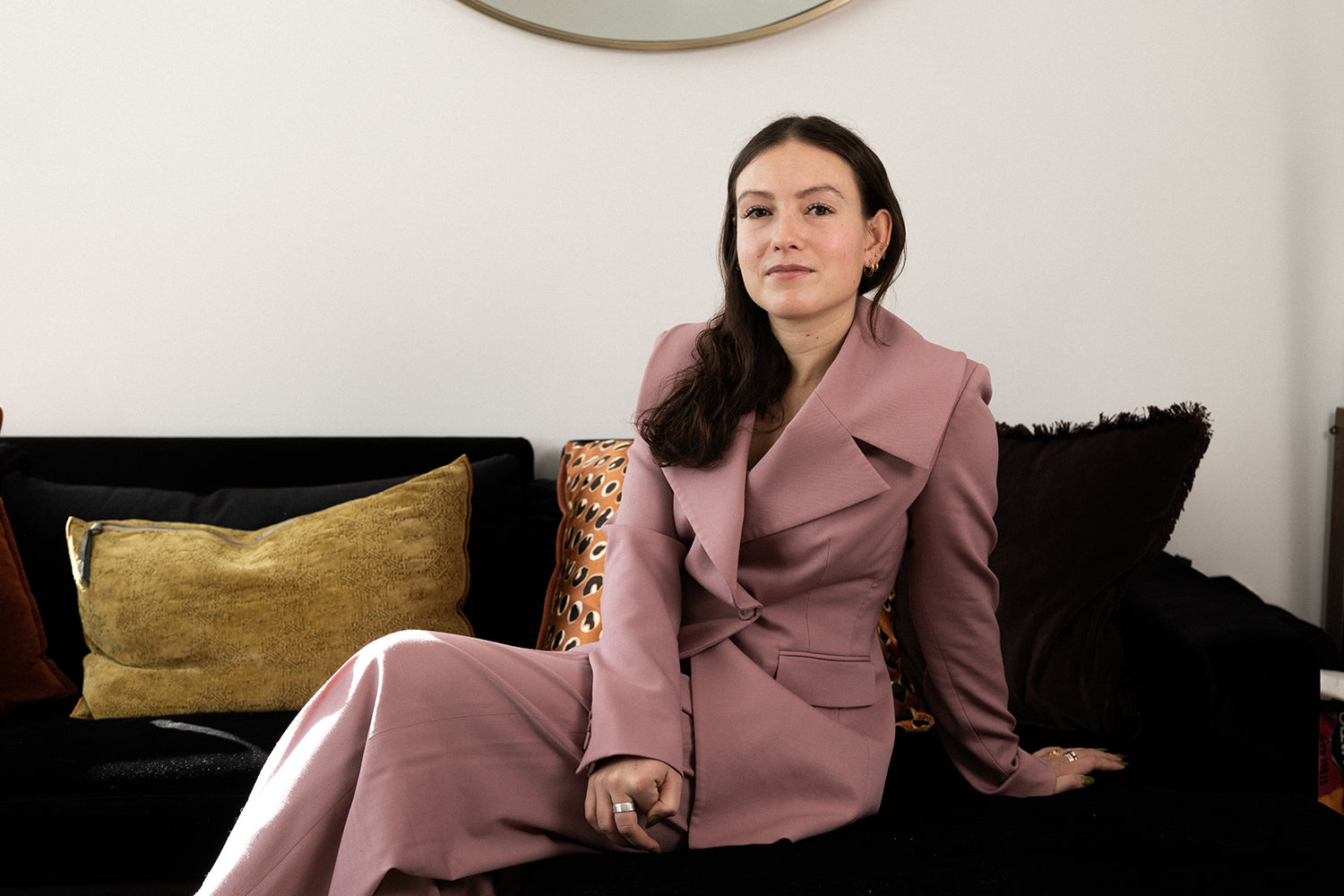 Emma Bates, founder of DIEM, sitting on a couch.