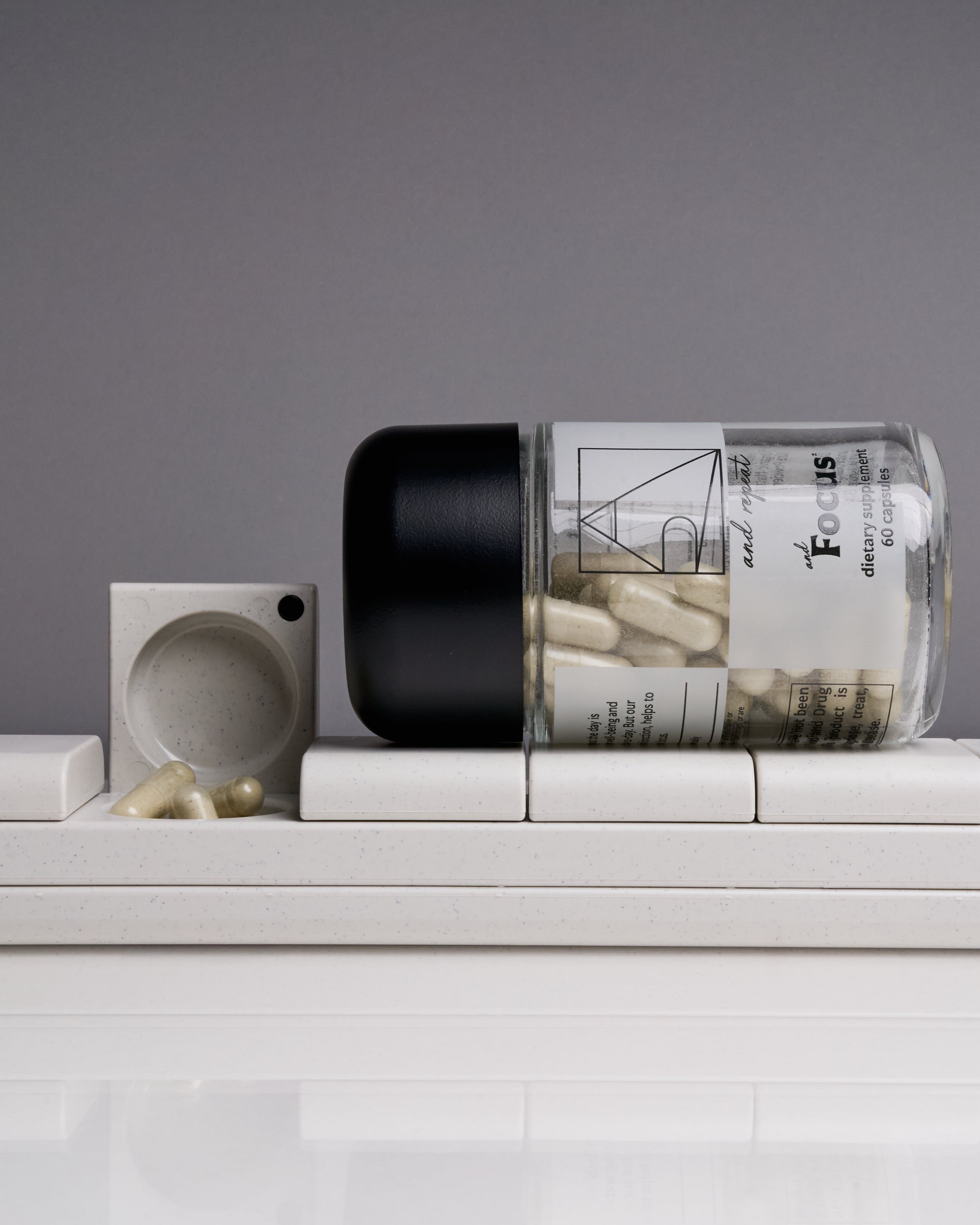 AndBundle 1.0 featuring AndFocus supplement bottle and AndAgain 7-Day Pill Case with open compartment—sleek, minimalist tools for daily wellness and mental clarity.