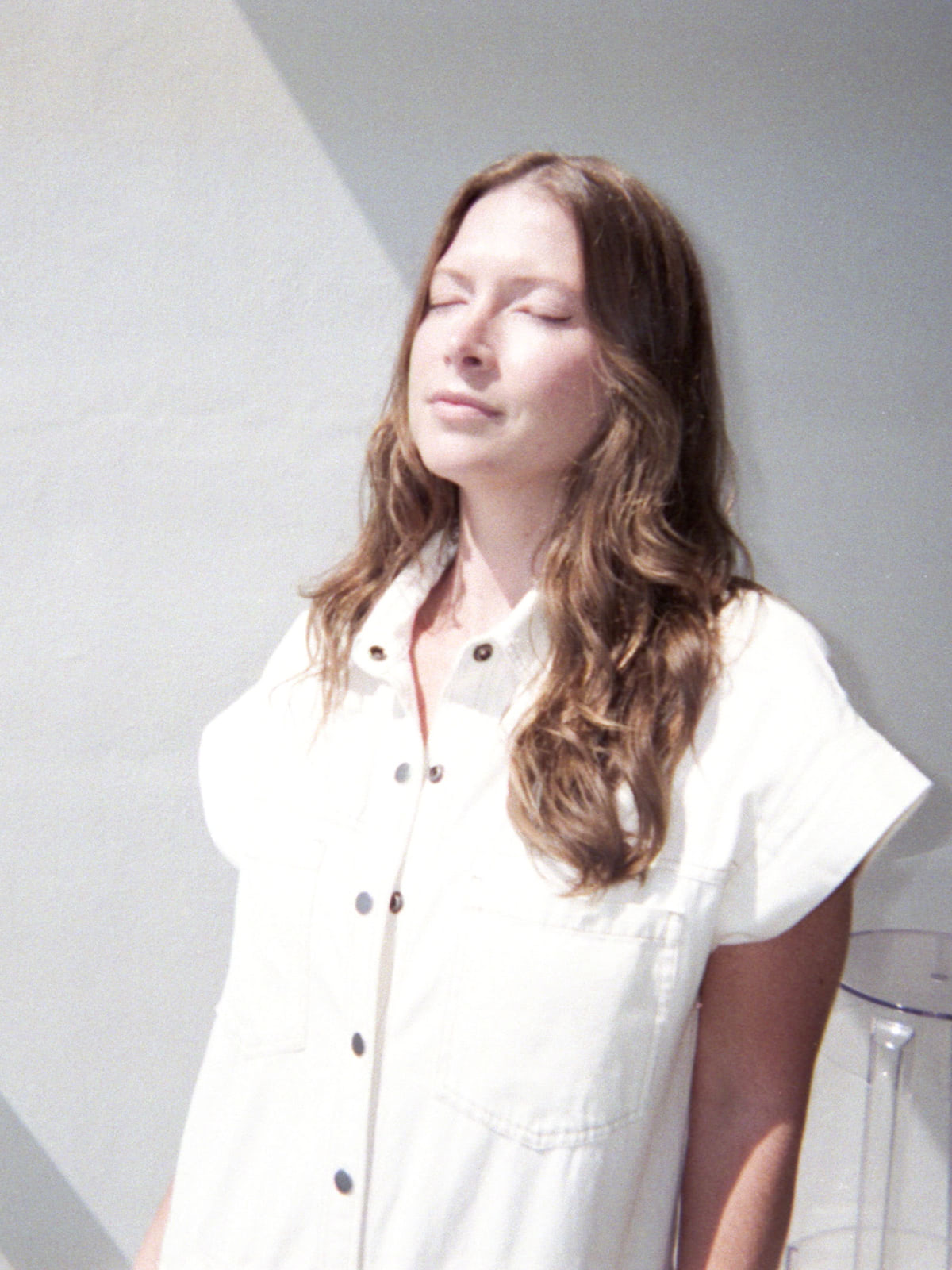 Dianna Cohen standing outside with her eyes closed in the sun