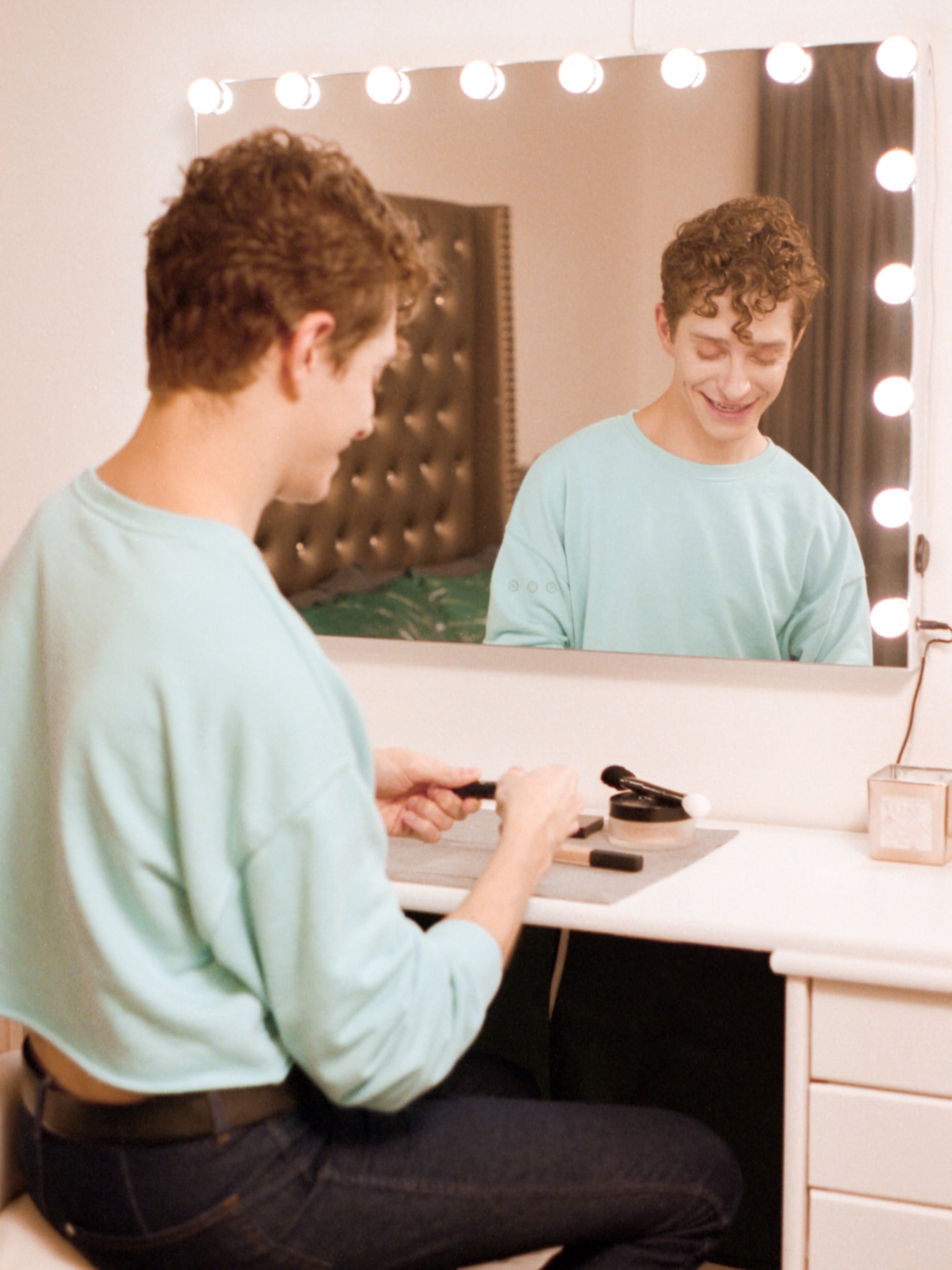 Actor Dino Petrera, sitting in front of a mirror opening makeup