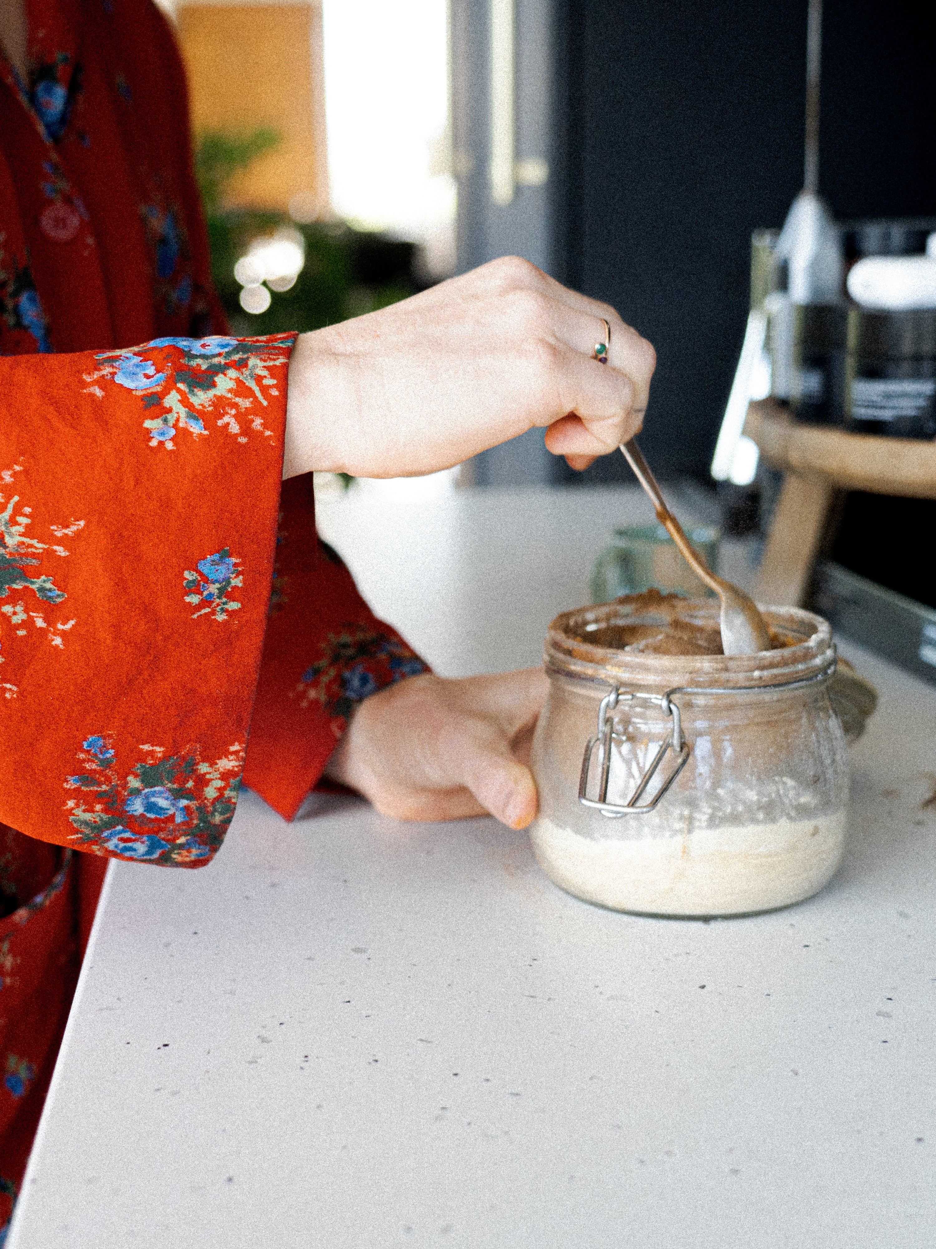 Kacie Carter, chef and co-founder of Honey Hi and holistic nutritionist stirring her supplement powder in a jar