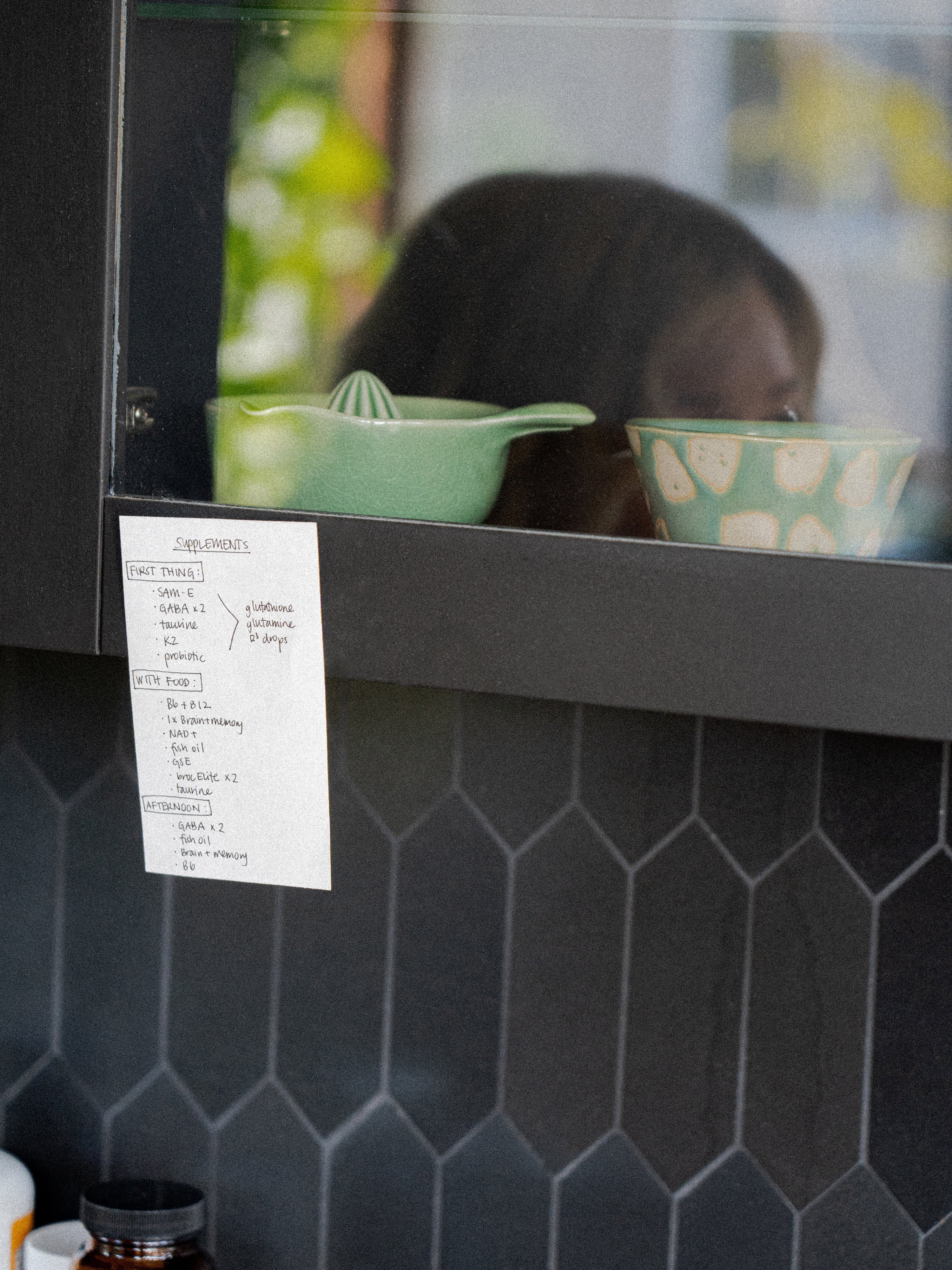 Kacie Carter's supplement list taped to her kitchen shelf