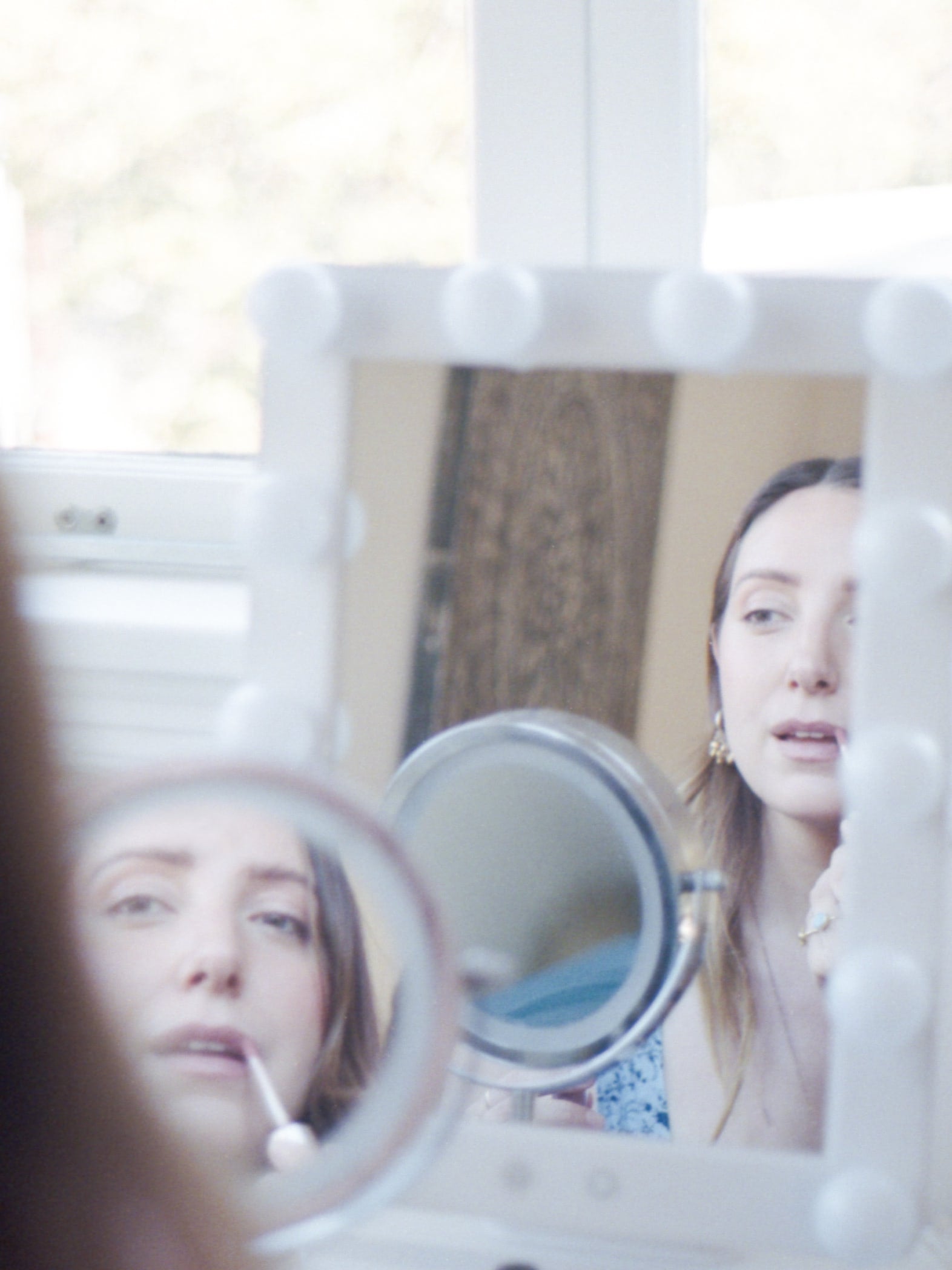 Merrady Wickes applying her lipstick in the mirror