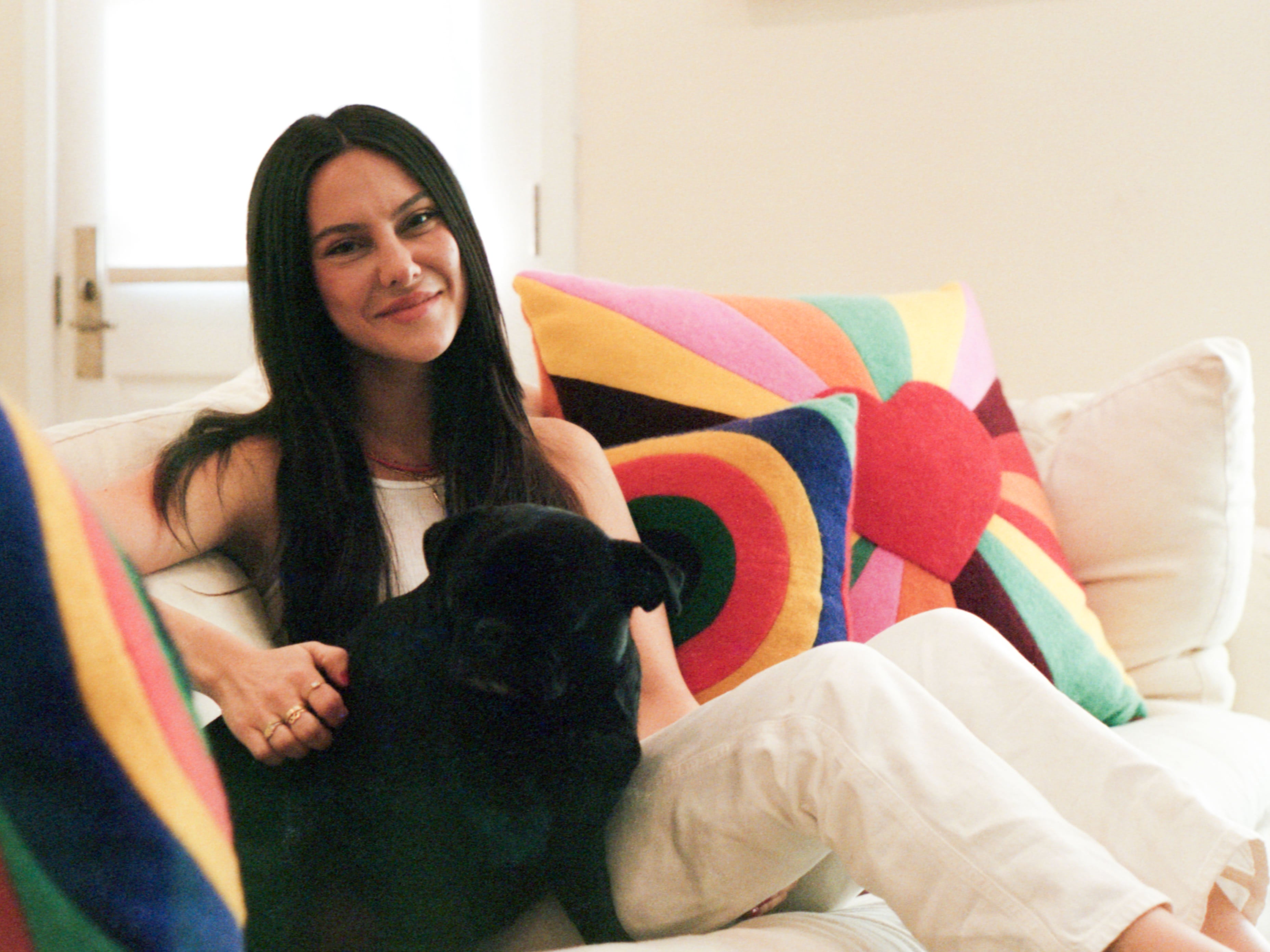Live From Bed Podcast Host, Jade Iovine sitting on her living room couch with her dog