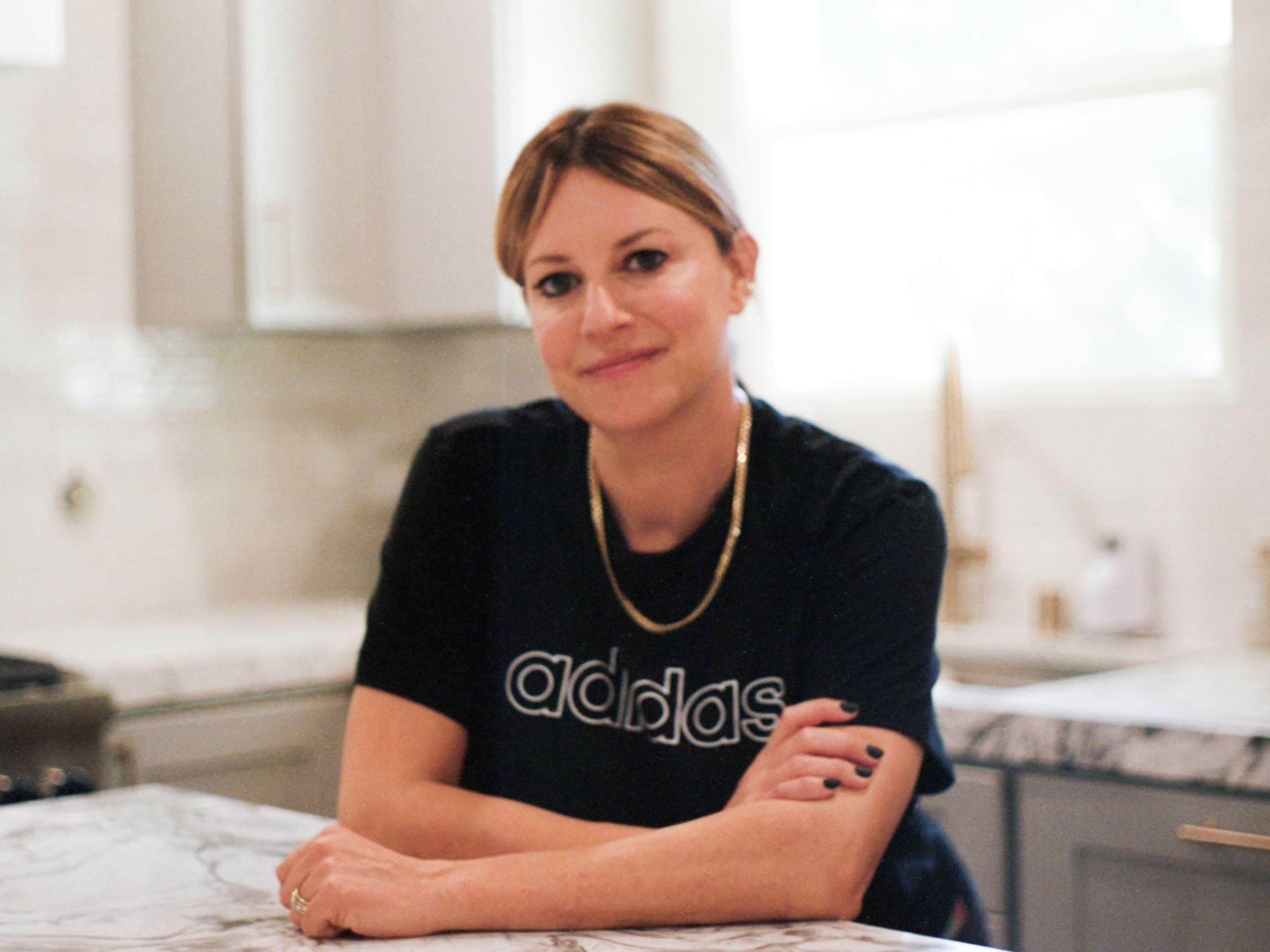 Celebrity makeup artist, Jamie Greenberg in her kitchen looking at the camera