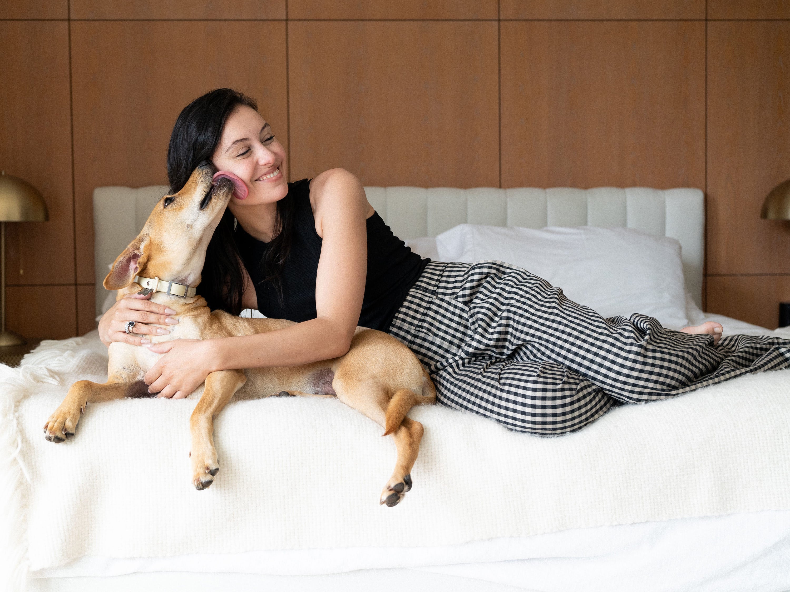 Marta Pozzan, model and actress, laying on her bed with her dog