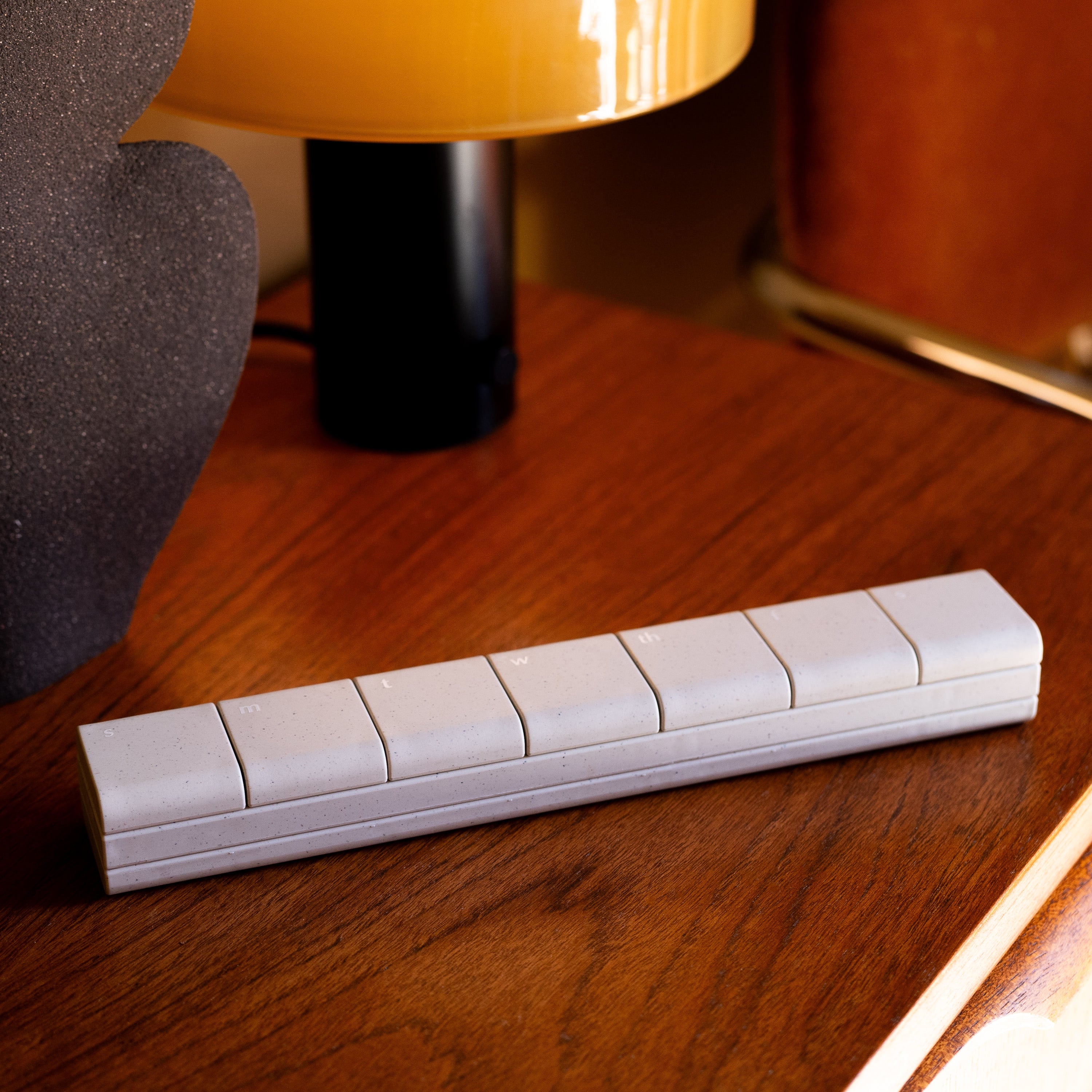 AndAgain 7-Day Pill Case on a stylish table, blending chic design with functional supplement storage for mental wellness.