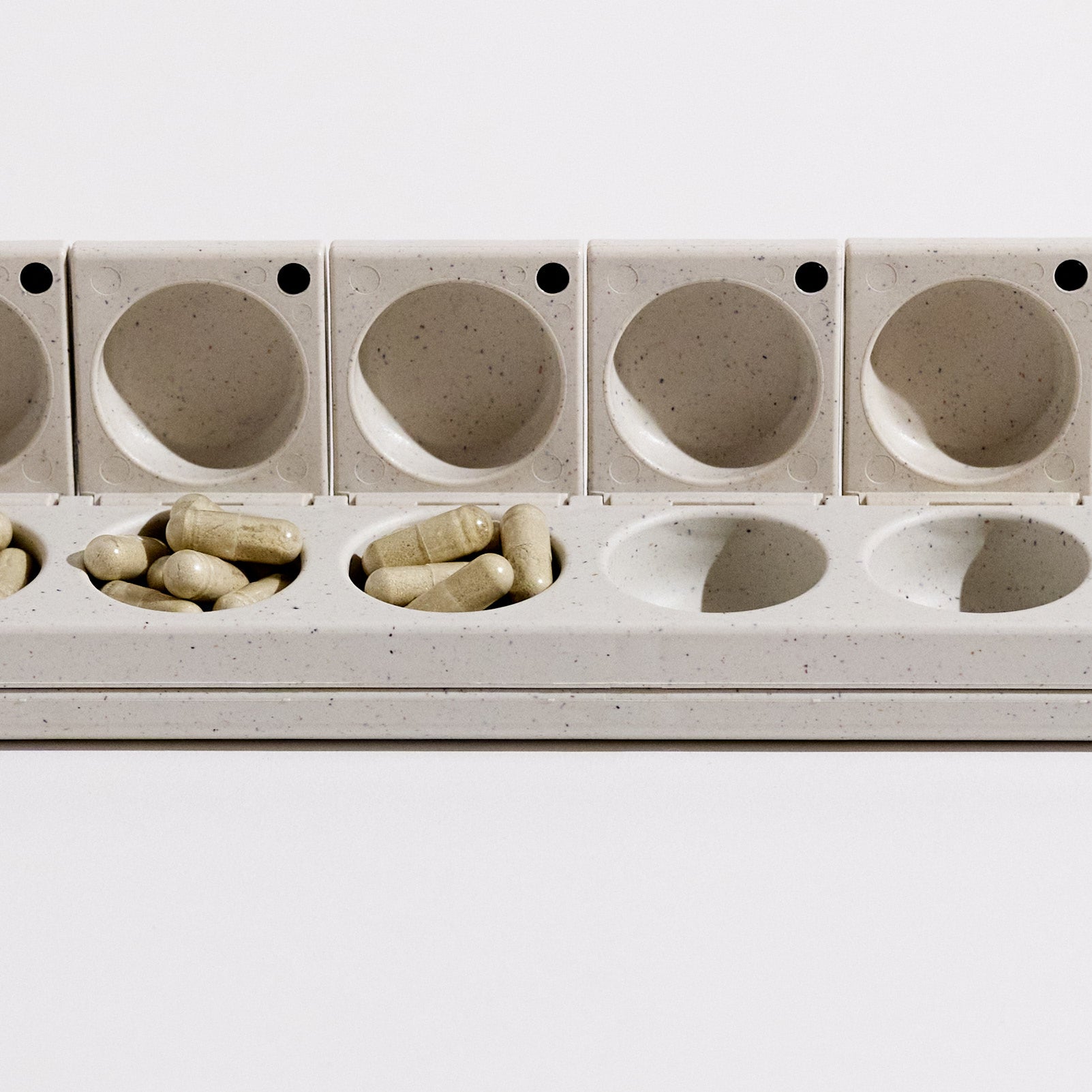 Close-up of the AndAgain 7-Day Pill Case with supplements, a modern and elegant organizer for daily vitamins and wellness.