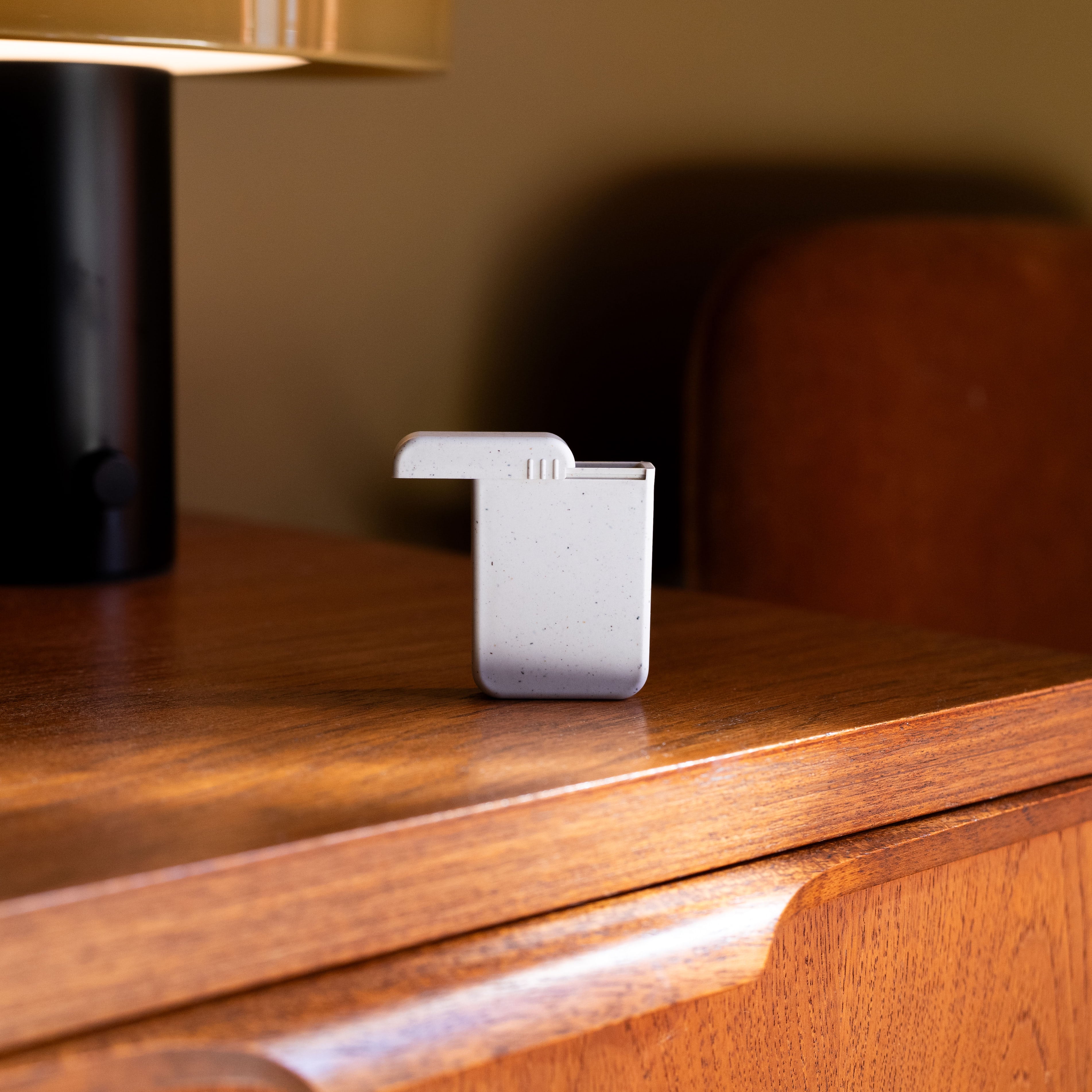 AndAround travel pill case resting on a wood table, a stylish and functional pill organizer.