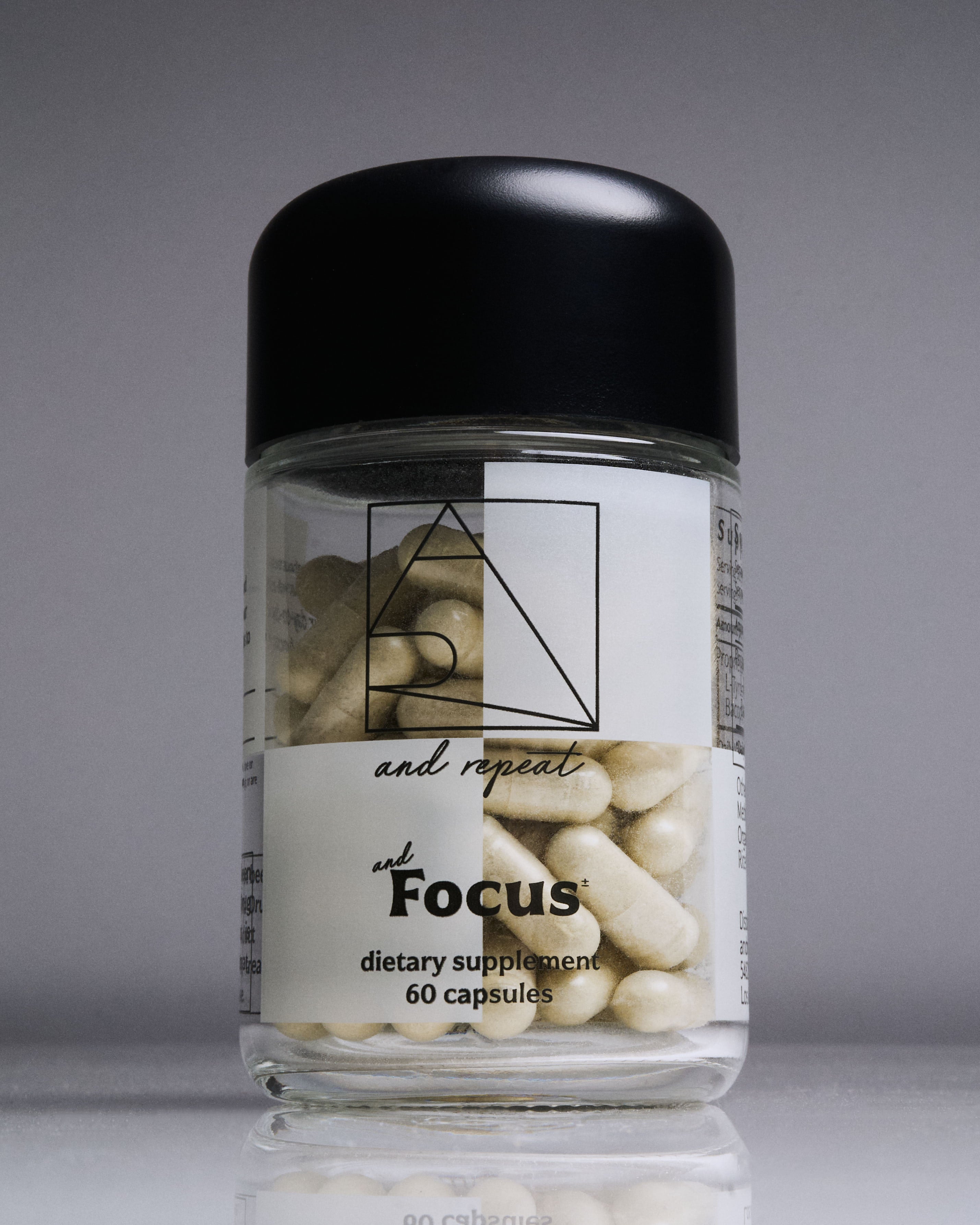 AndFocus supplement bottle upright on seamless surface—sleek design with 60 vegan capsules for cognitive support and mental wellness.