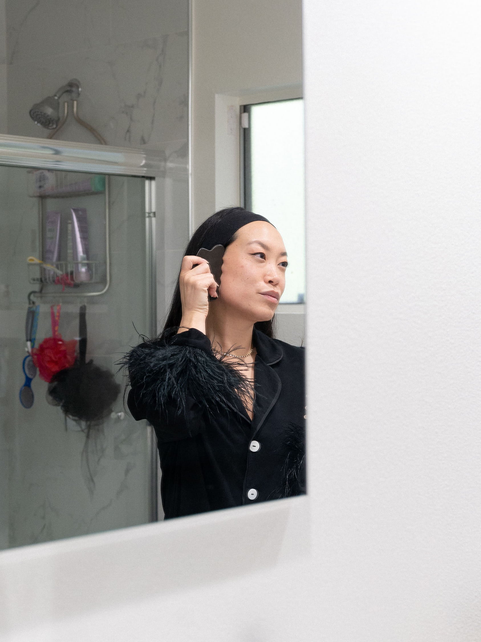 The publicist and founder of SixTen PR, Jen Woodward looking herself in the mirror while working on her skincare