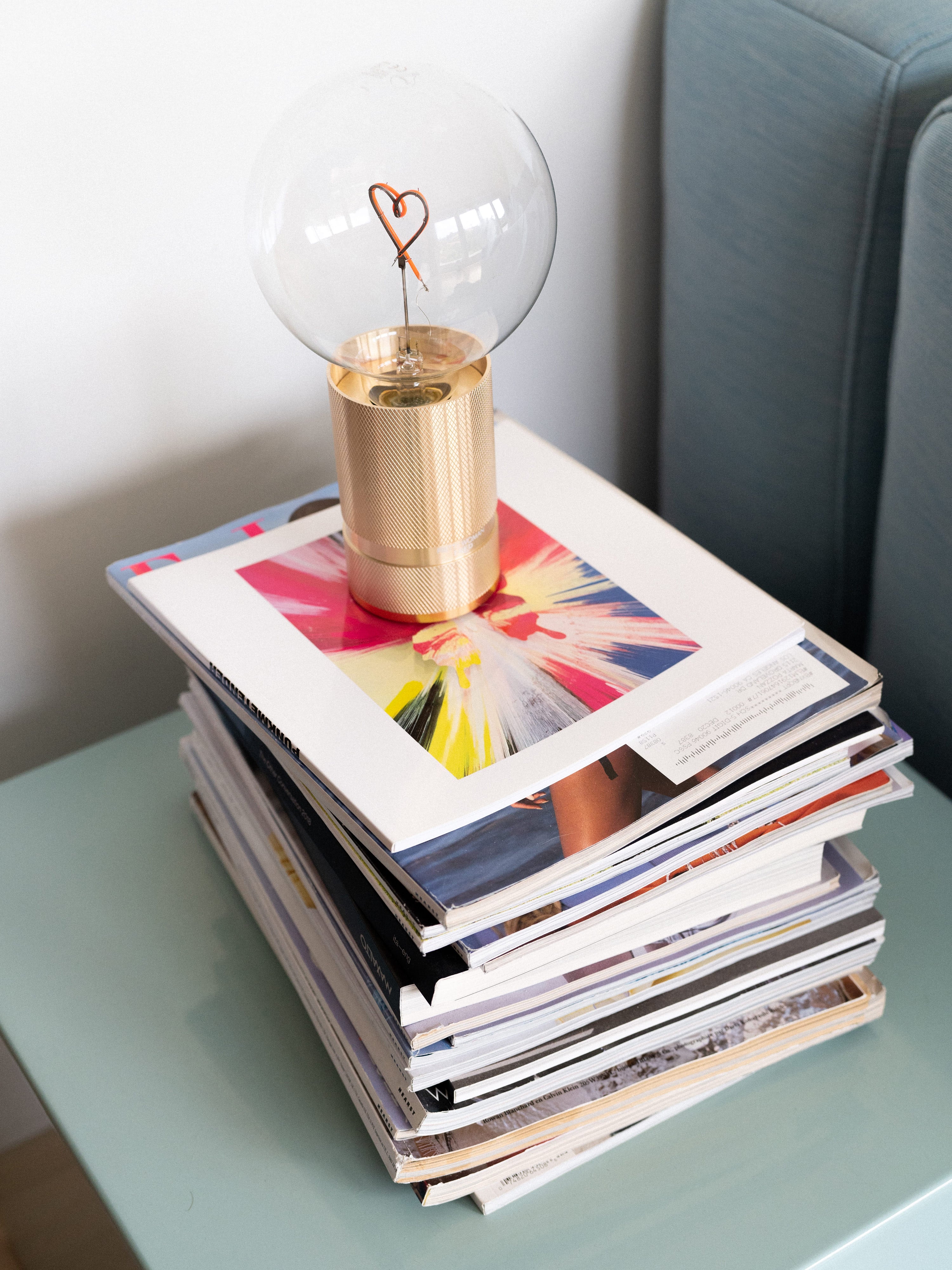 Marta Pozzan's magazines and lamp with a heart in it on a side table
