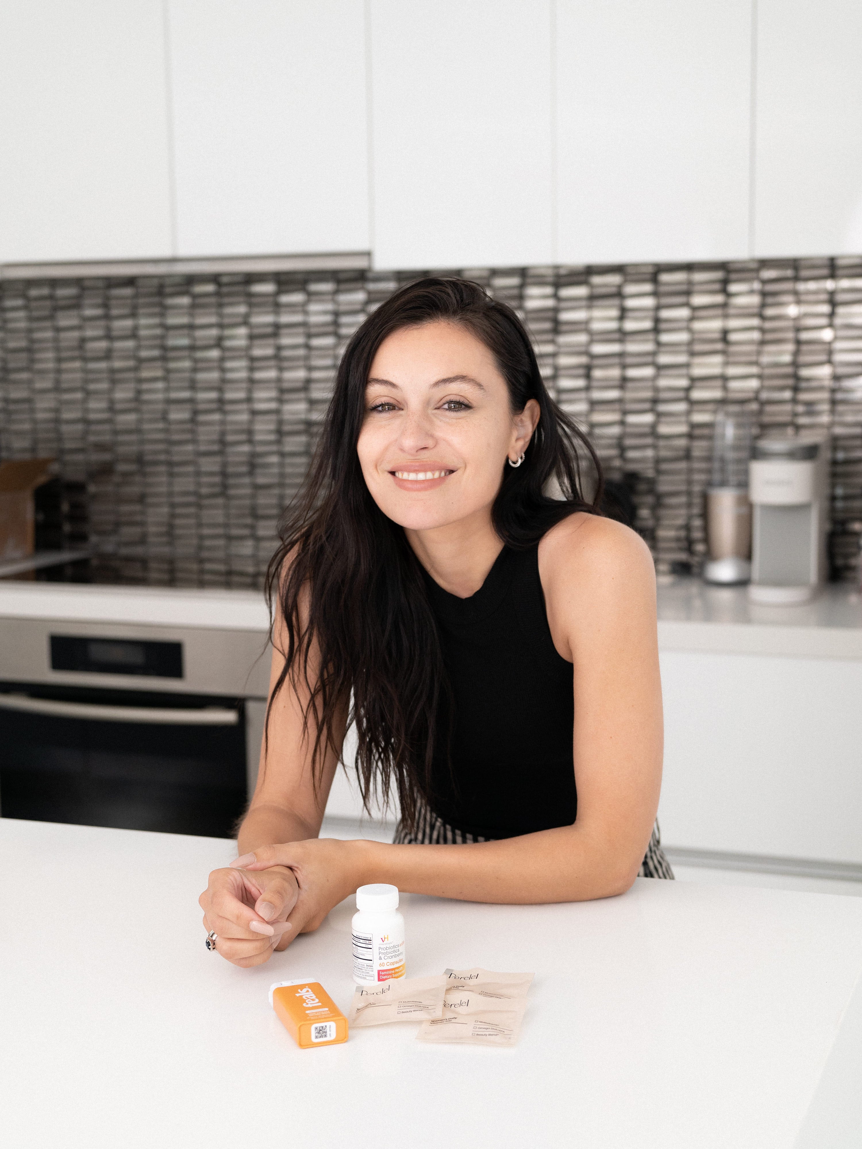 Marta Pozzan in her kitchen with her supplements on her countertop