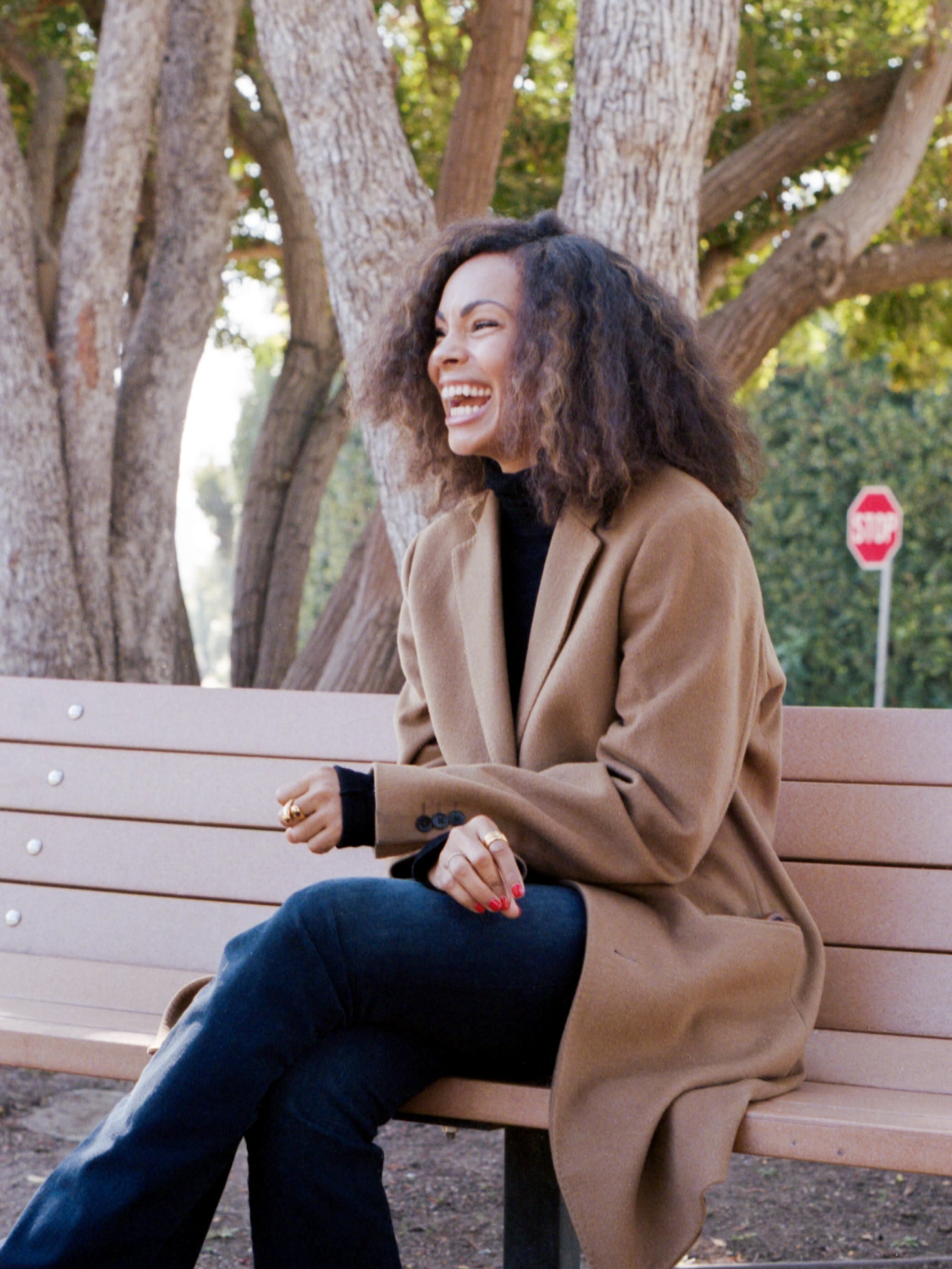 Maxine Goynes sitting on a park bench, laughing