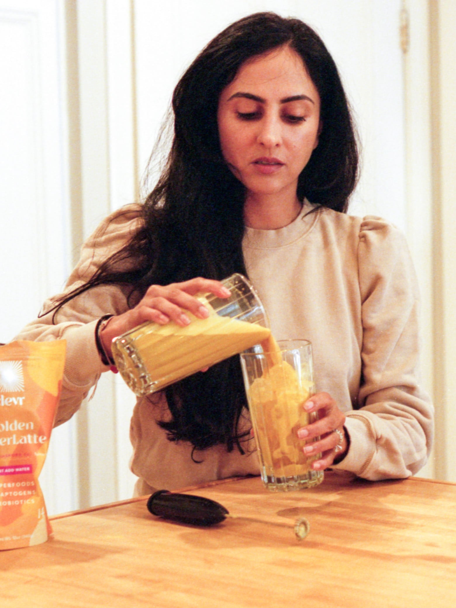 Michelle Ranavat pouring herself a golden latte